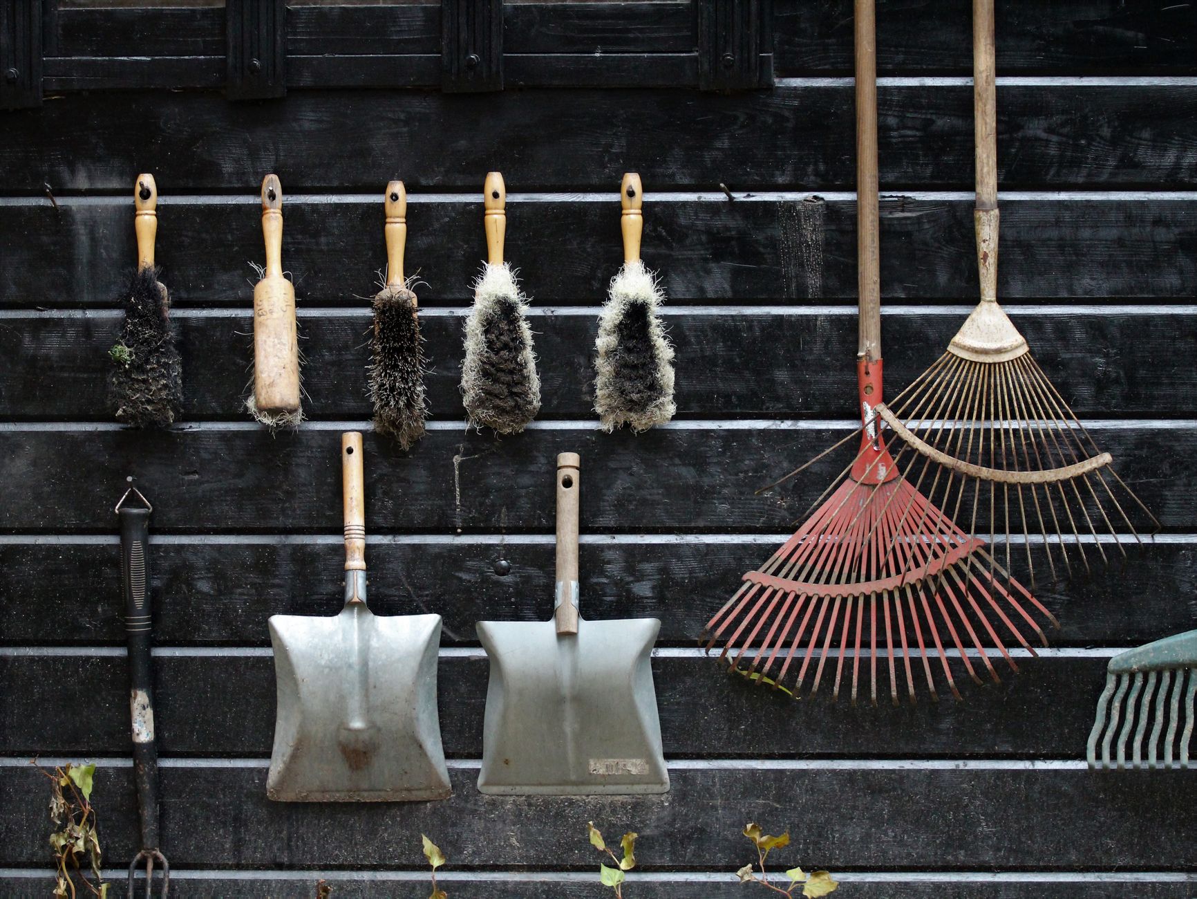 Garden tools hanging on a shed wall