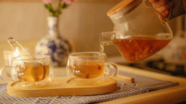 Pouring tea from a glass teapot into cups