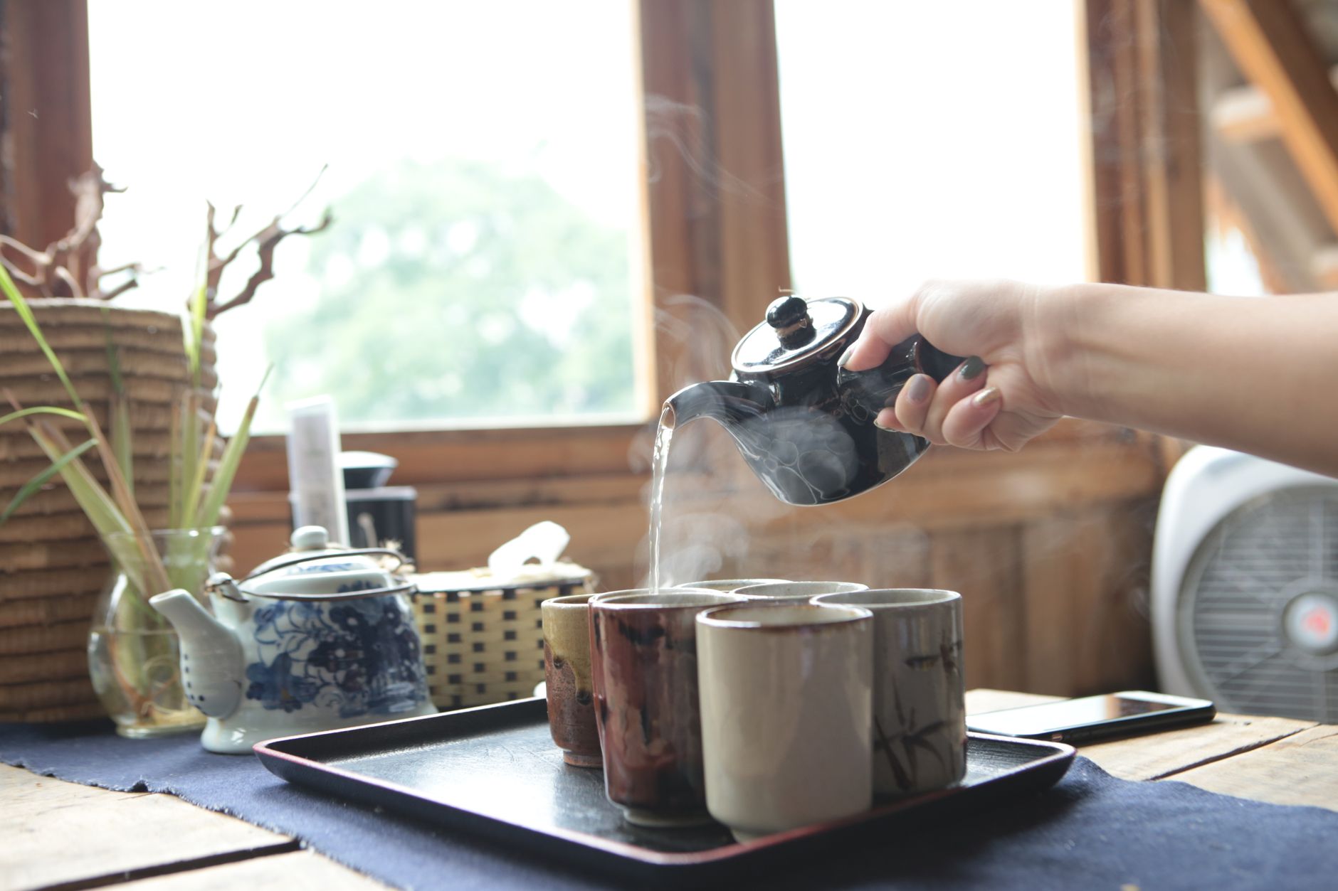 Pouring hot water from a kettle into cups