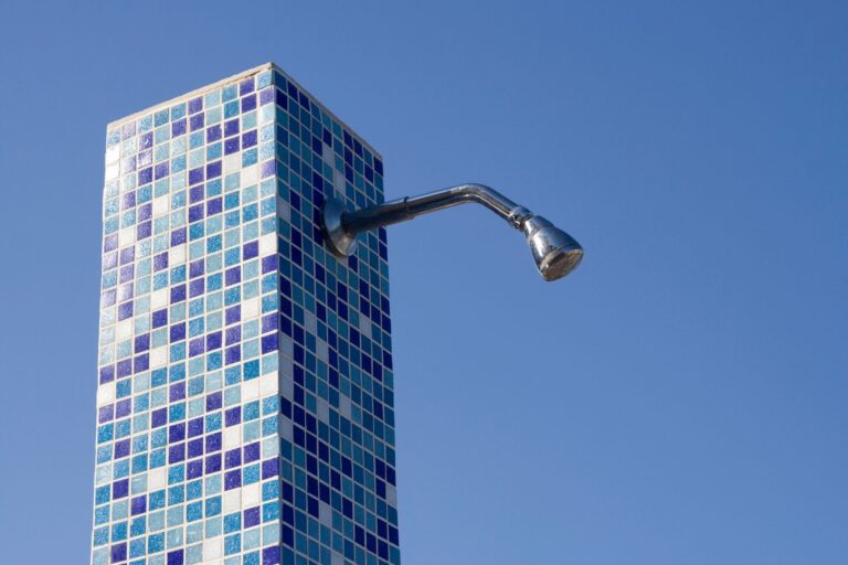 Best electric tankless water heater: an outdoor shower head on a tiled column