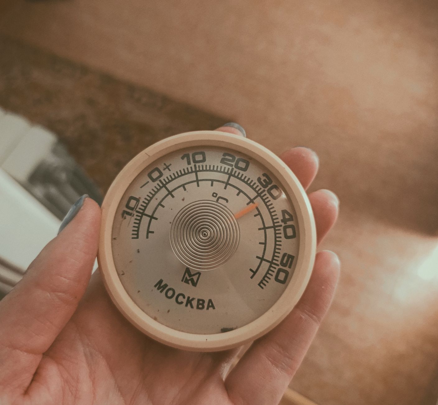 A dial thermometer in a hand