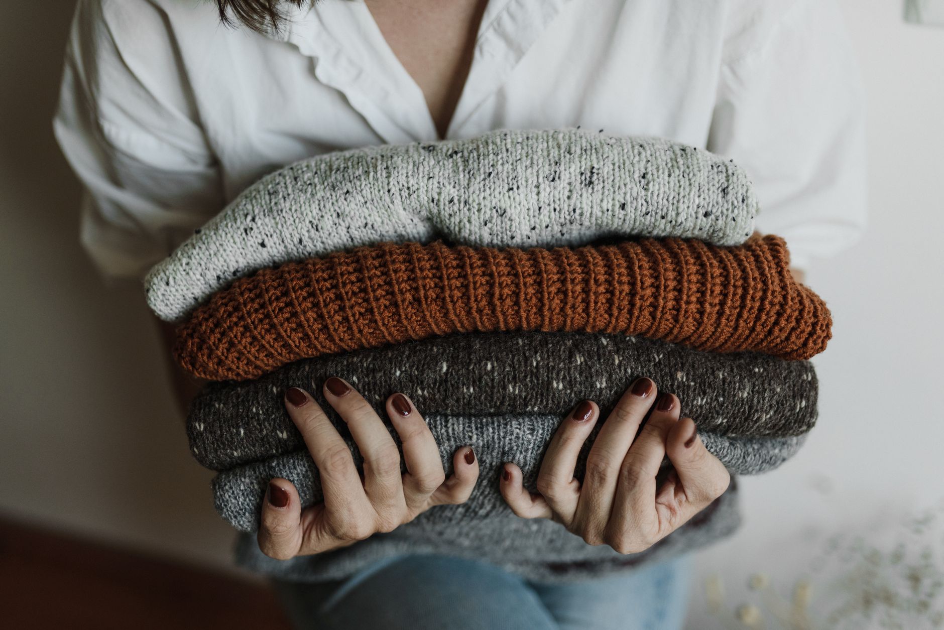 Best fabric shaver: a stack of folded knit sweaters