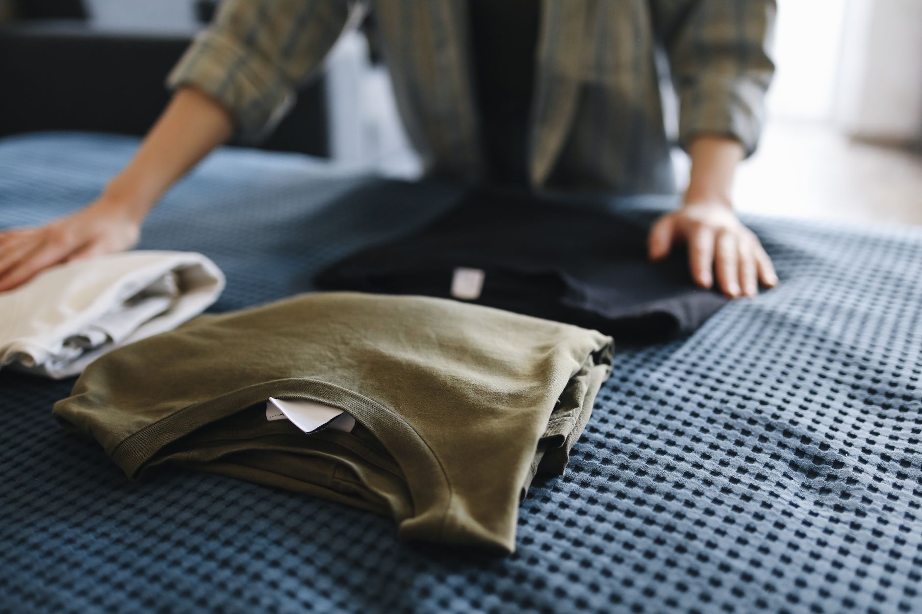 Folding clothes on a bed