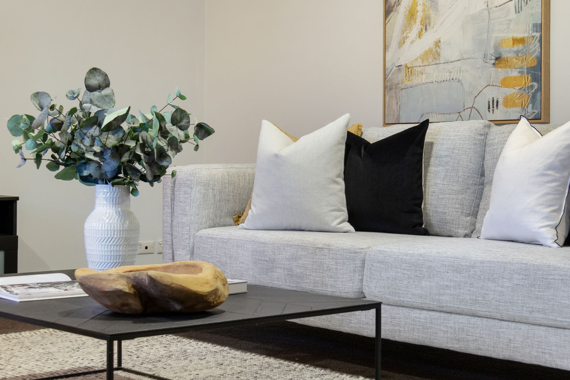 A gray sofa with pillows and a coffee table