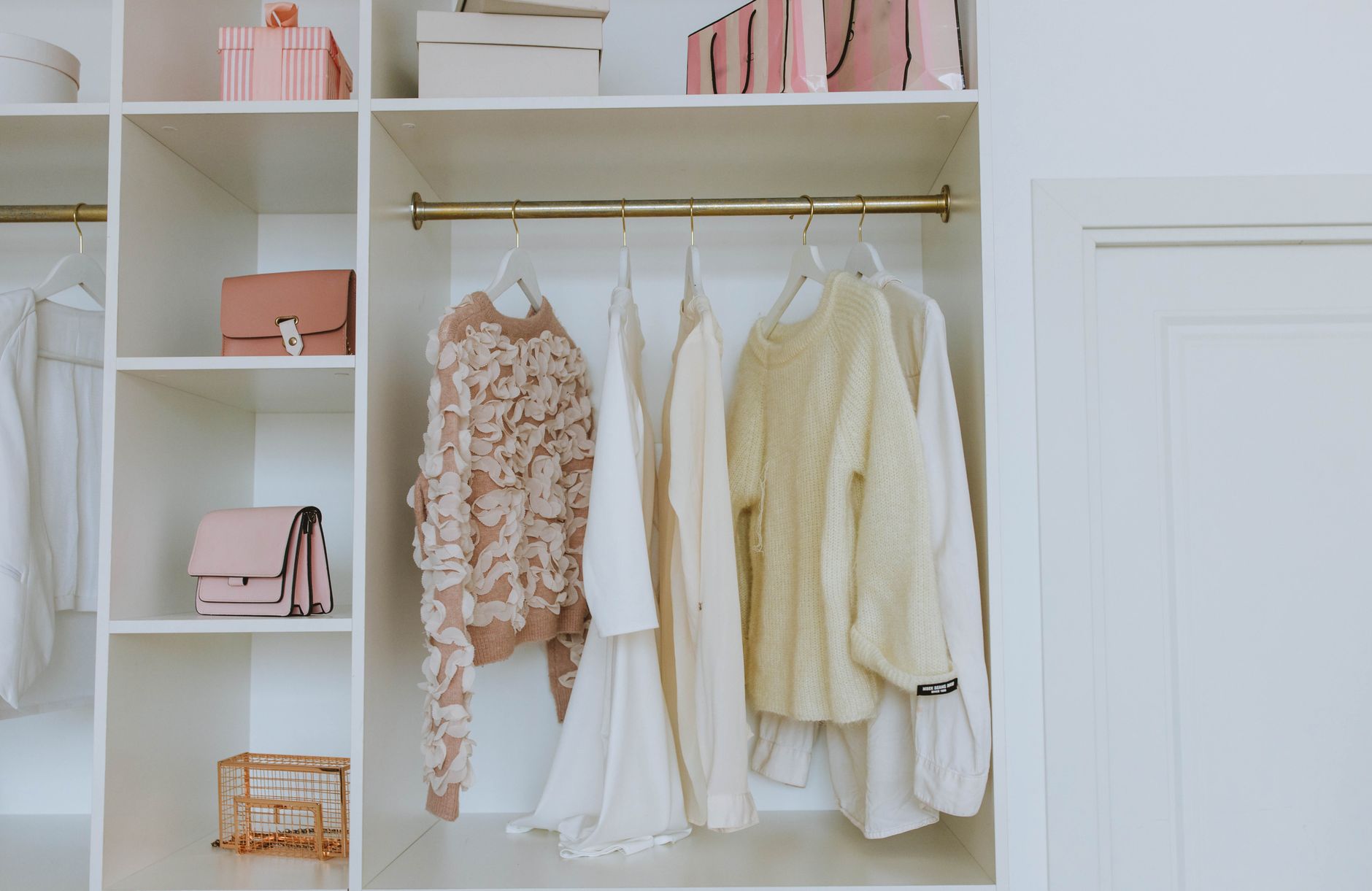 Sweaters hanging in an open closet