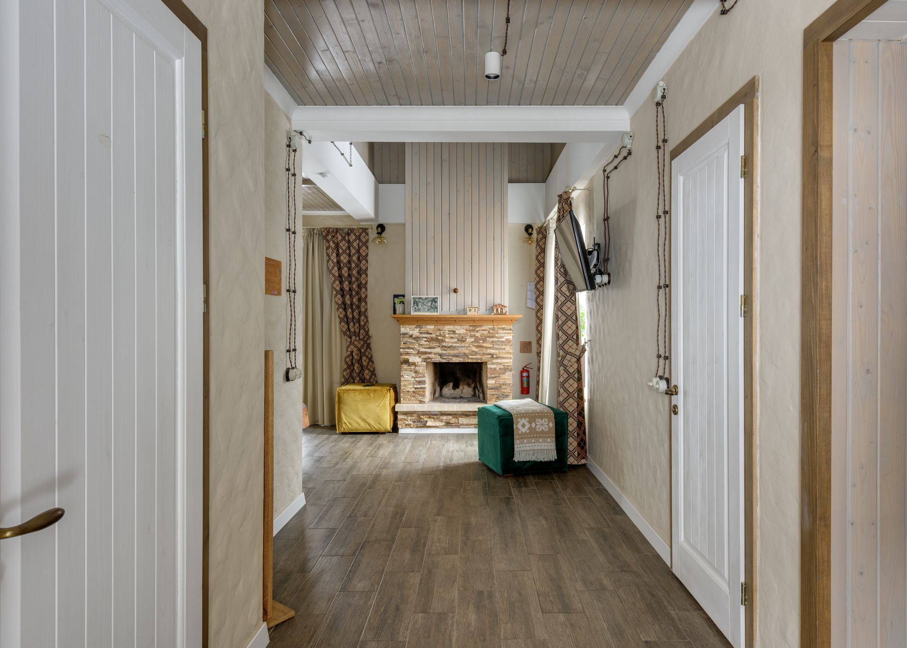 A hallway leading to a stone fireplace