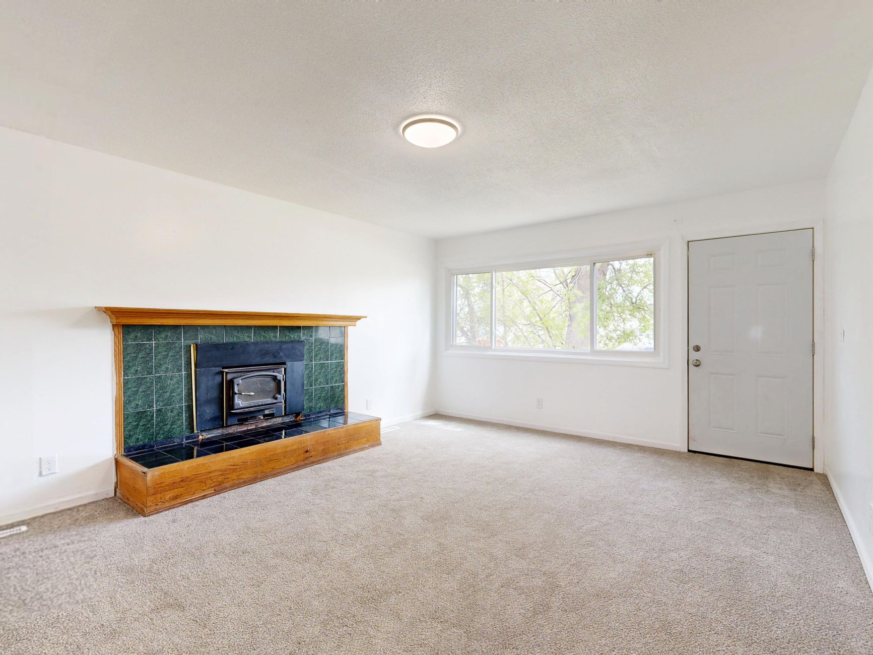 An empty room with a tiled fireplace