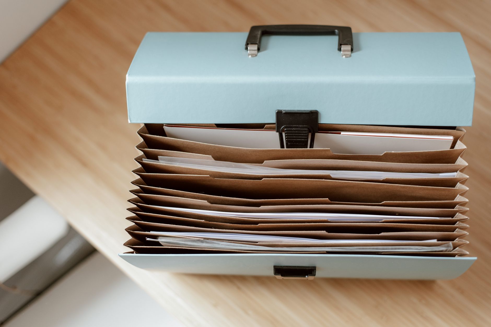 An accordion file box with paper folders