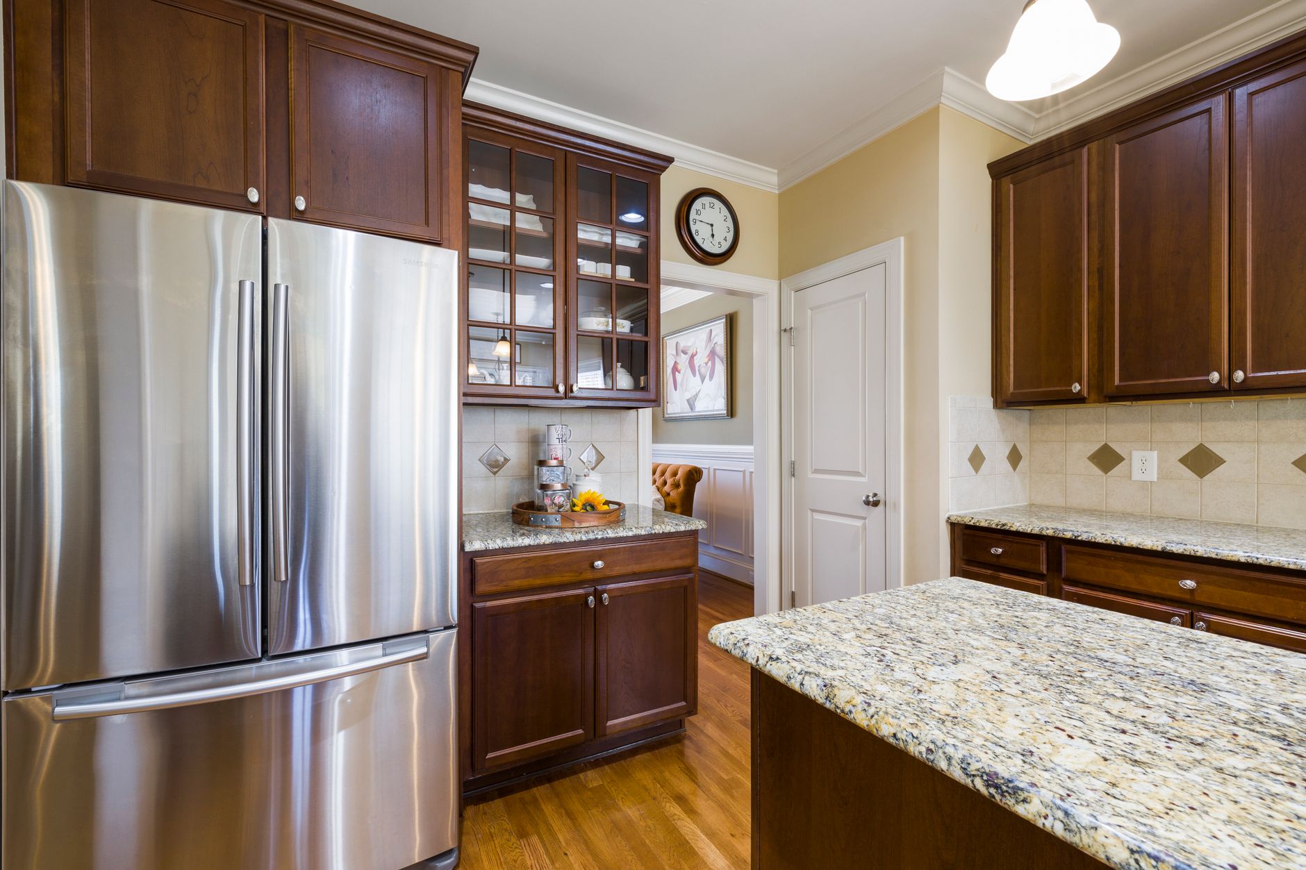 A kitchen with a stainless refrigerator