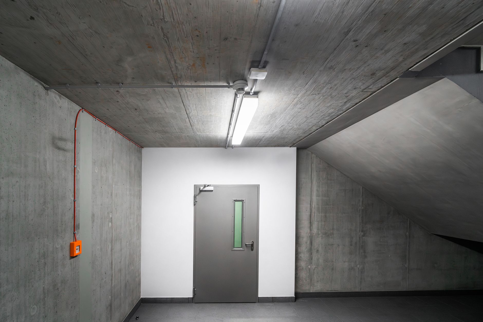 A door at the end of a concrete hallway