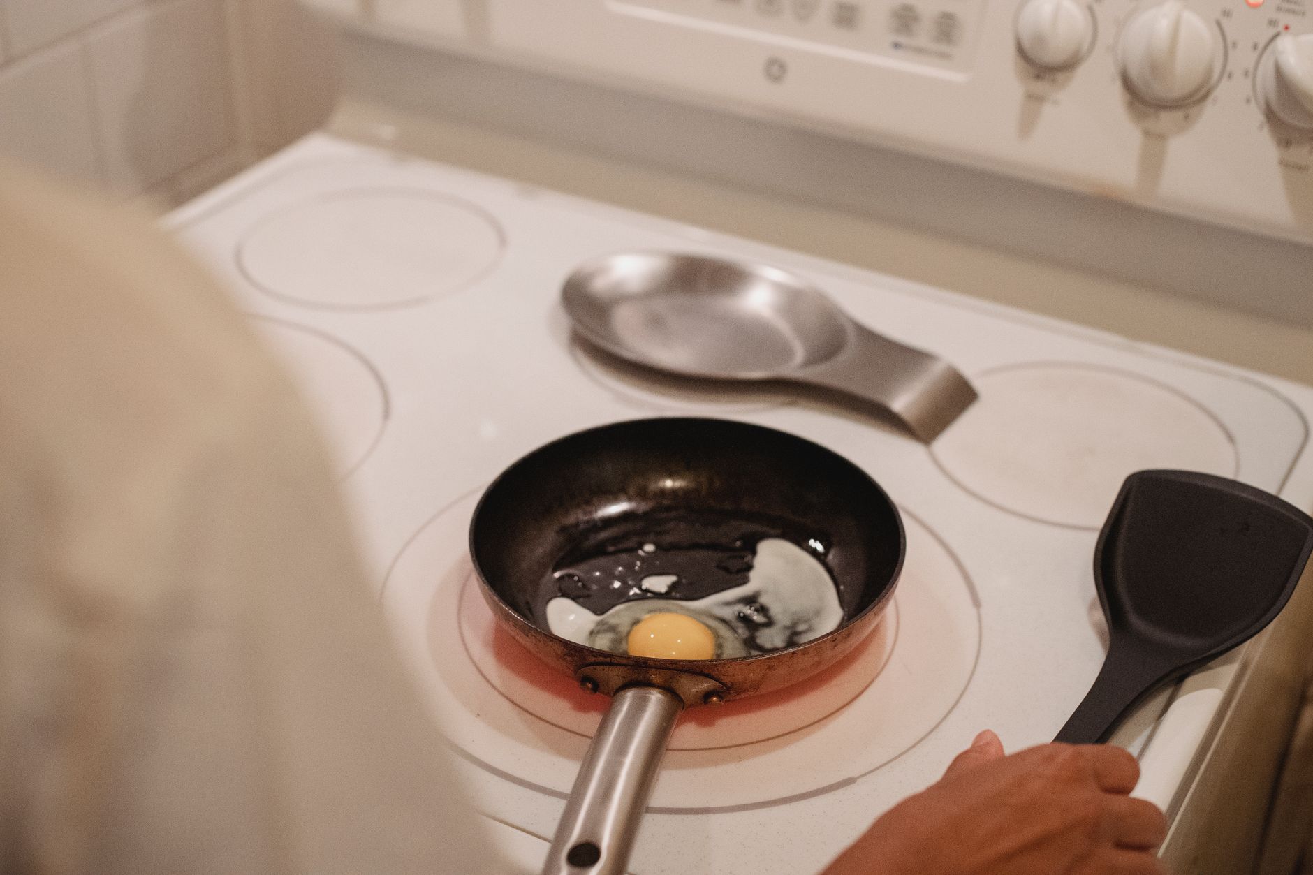 Frying an egg in a pan on a stove