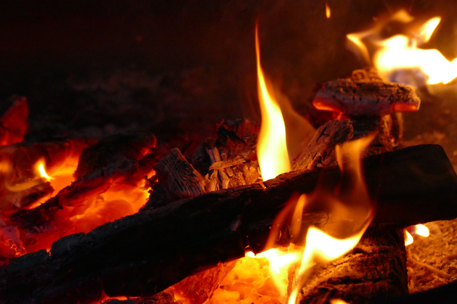 Embers glowing under a burning log
