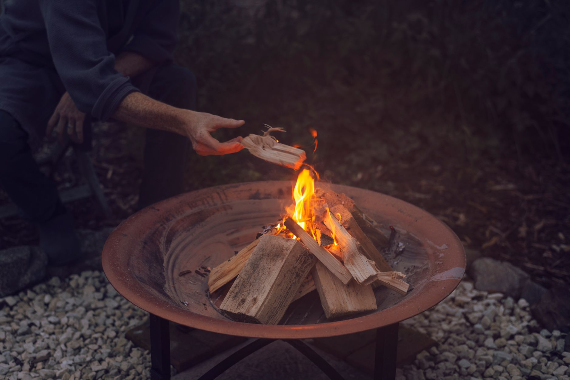 Best fire pit cover: a round fire pit in a backyard at dusk