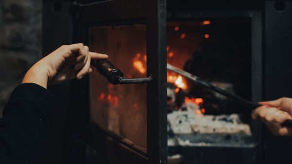 Best fireplace glass cleaner: opening a wood stove door to tend the fire