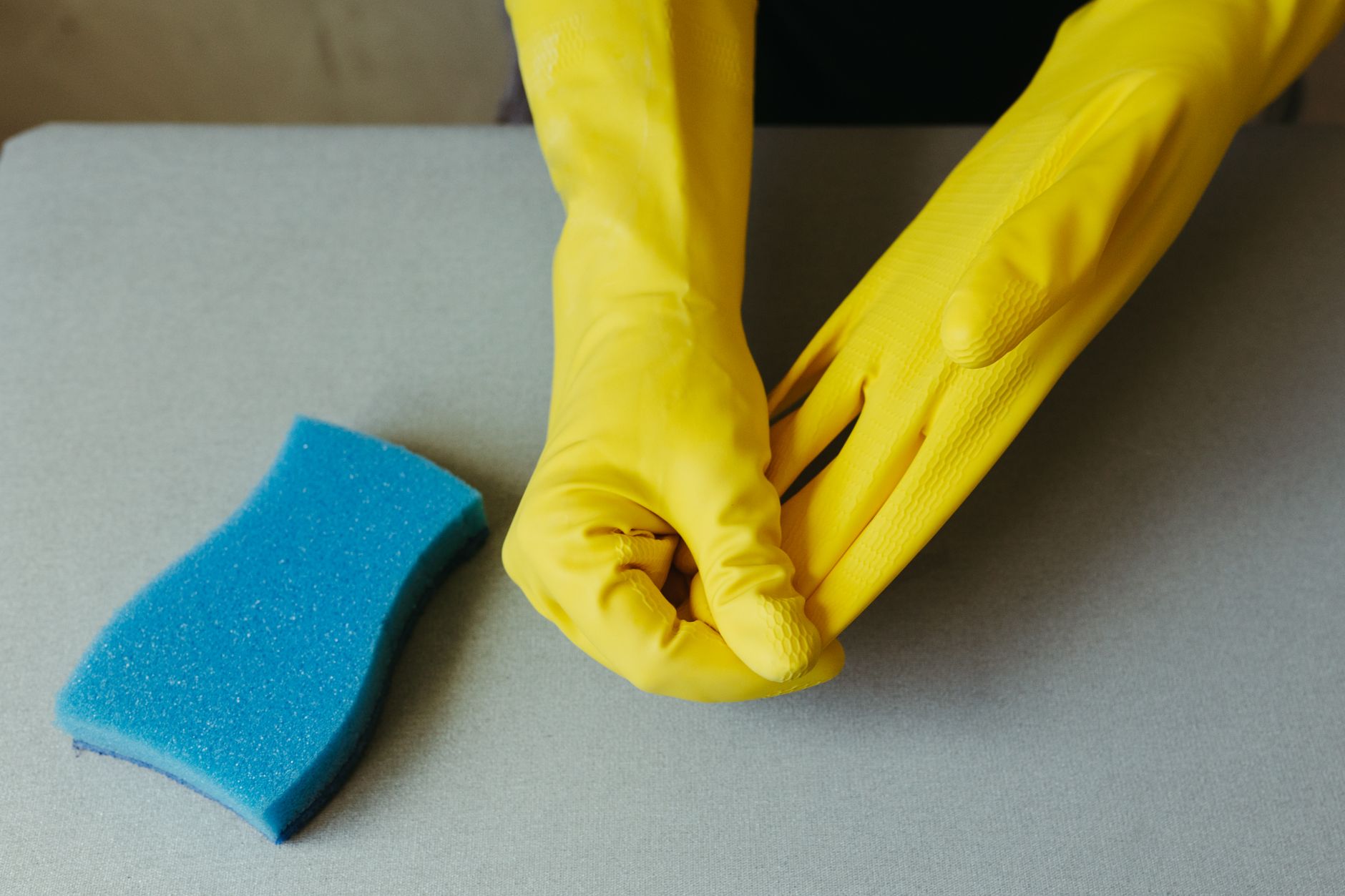 Gloved hands with a cleaning sponge