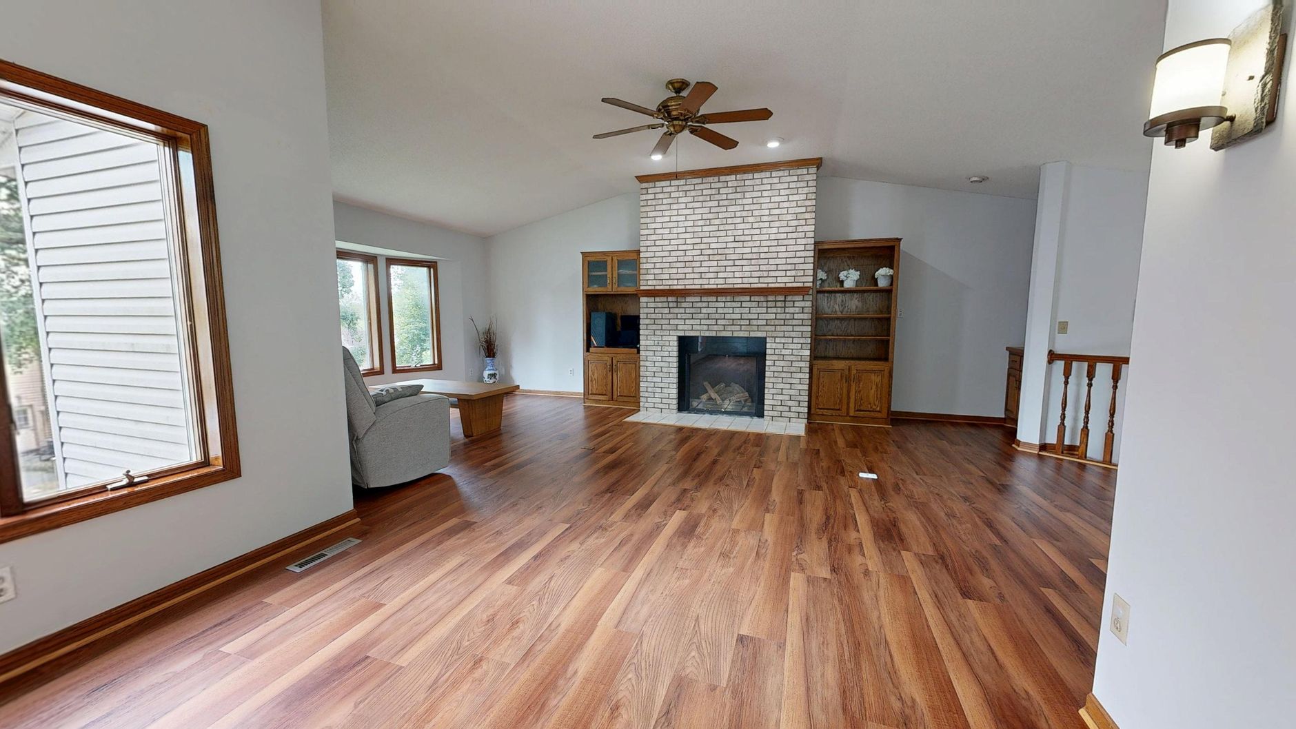 A living room with a white brick fireplace