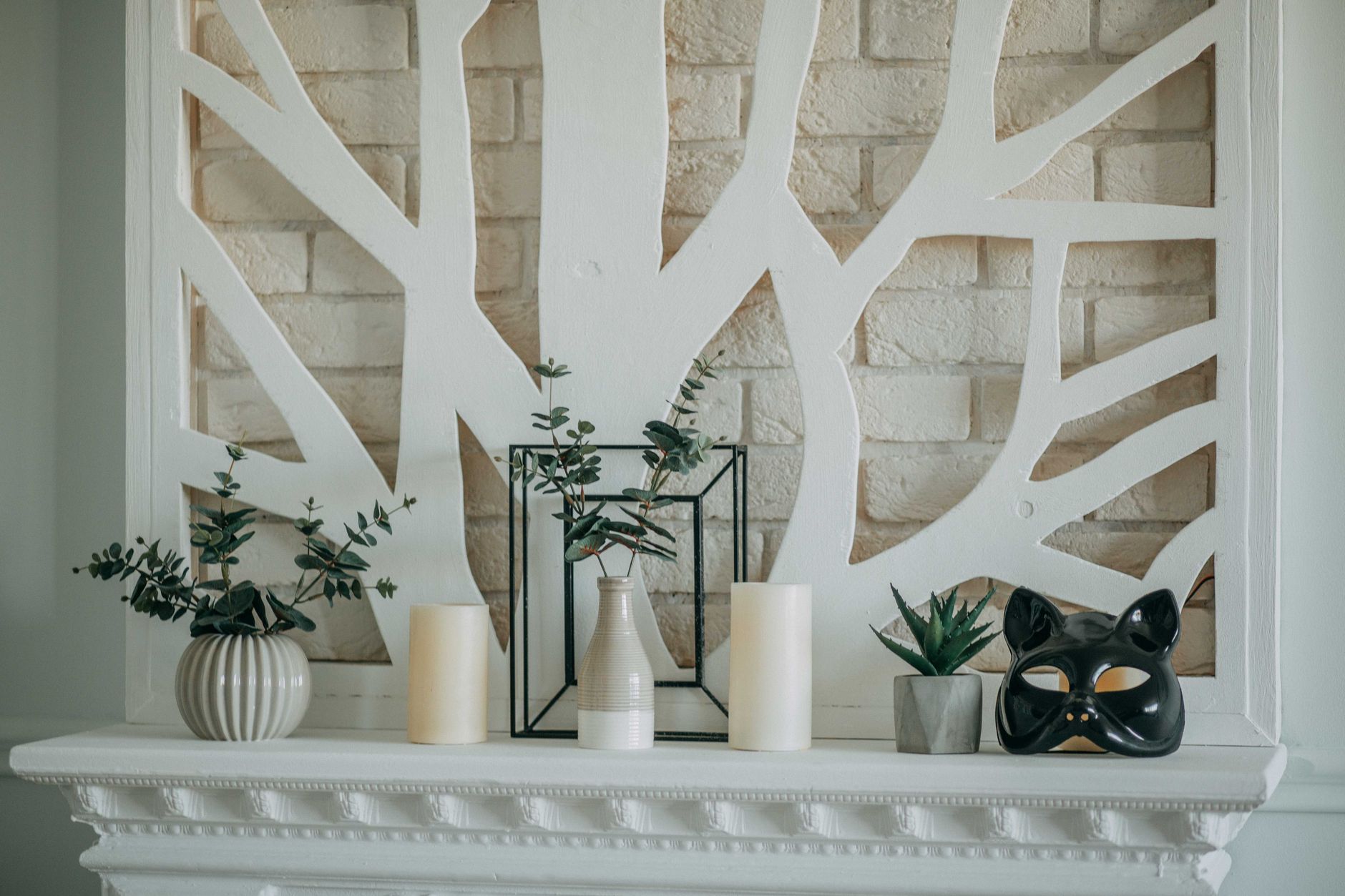 Candles and plants on a white mantel