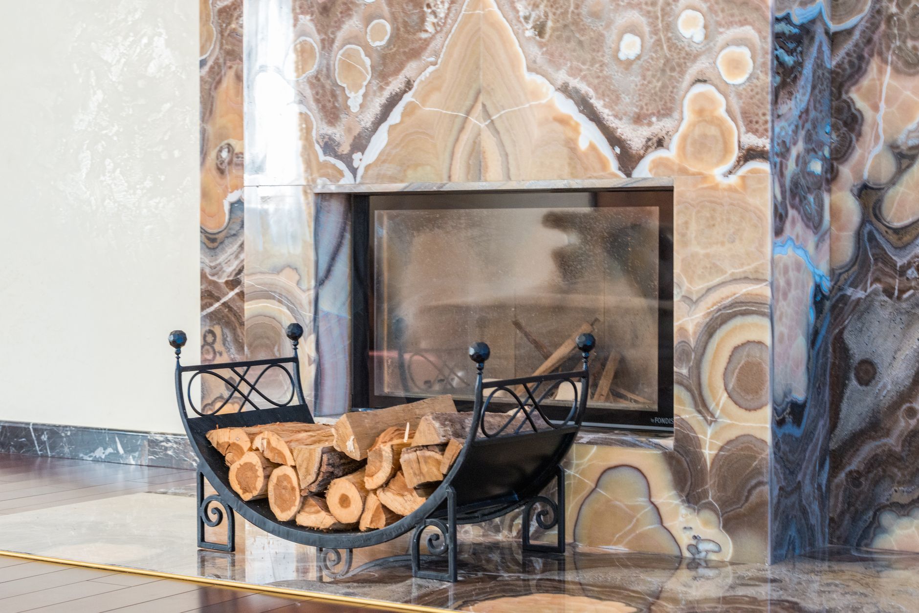 Best fireplace tool set: a log holder beside a marble fireplace