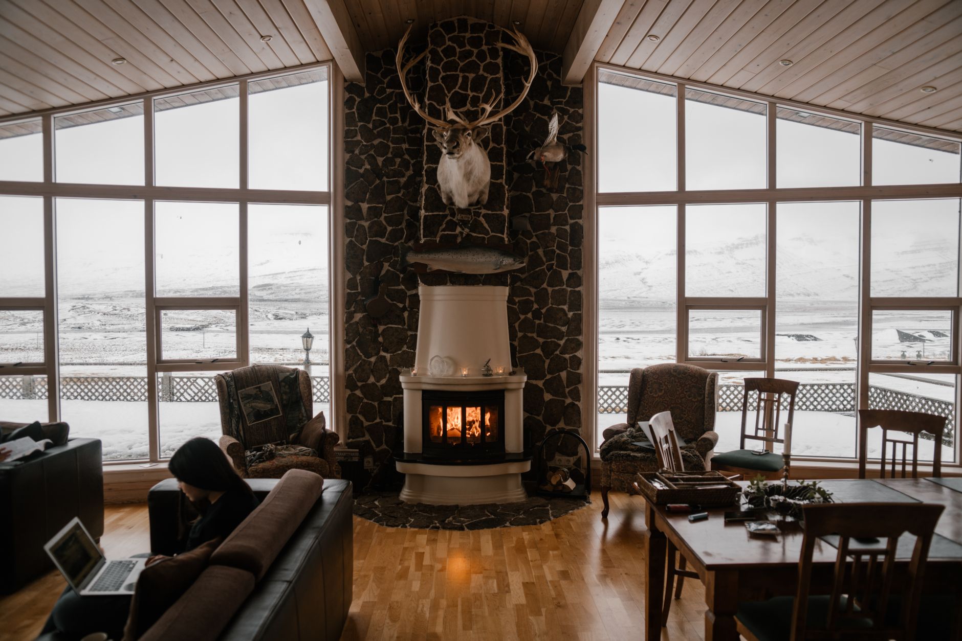 A living room with a fireplace and large windows