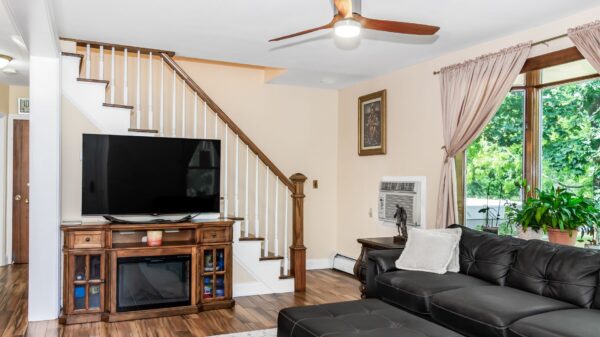 Best fireplace tv stand: a TV on a fireplace media console by a staircase