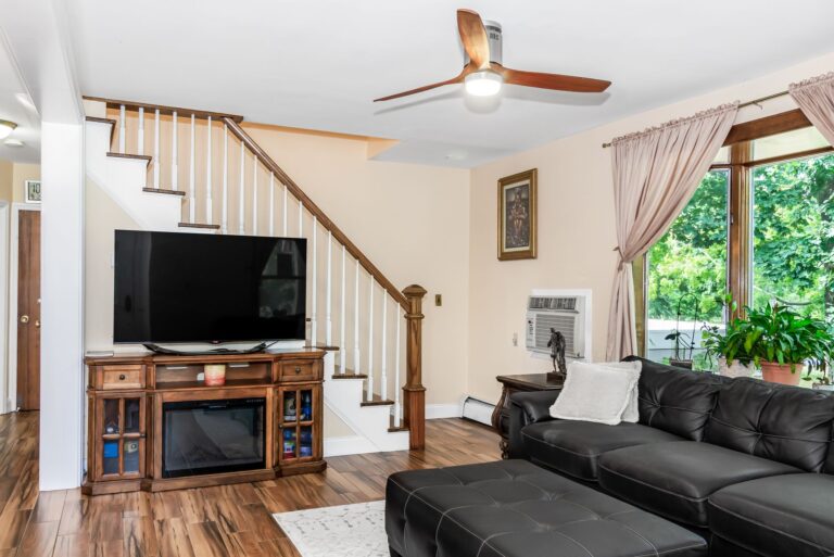 Best fireplace tv stand: a TV on a fireplace media console by a staircase