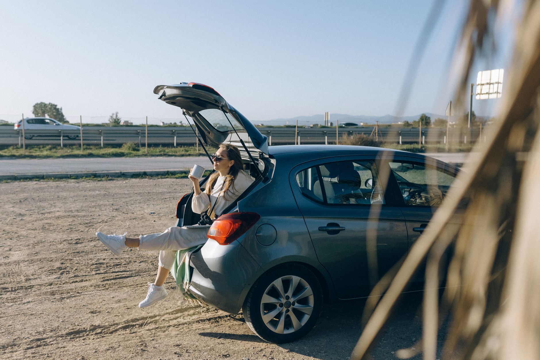 A woman sitting in an open car hatch
