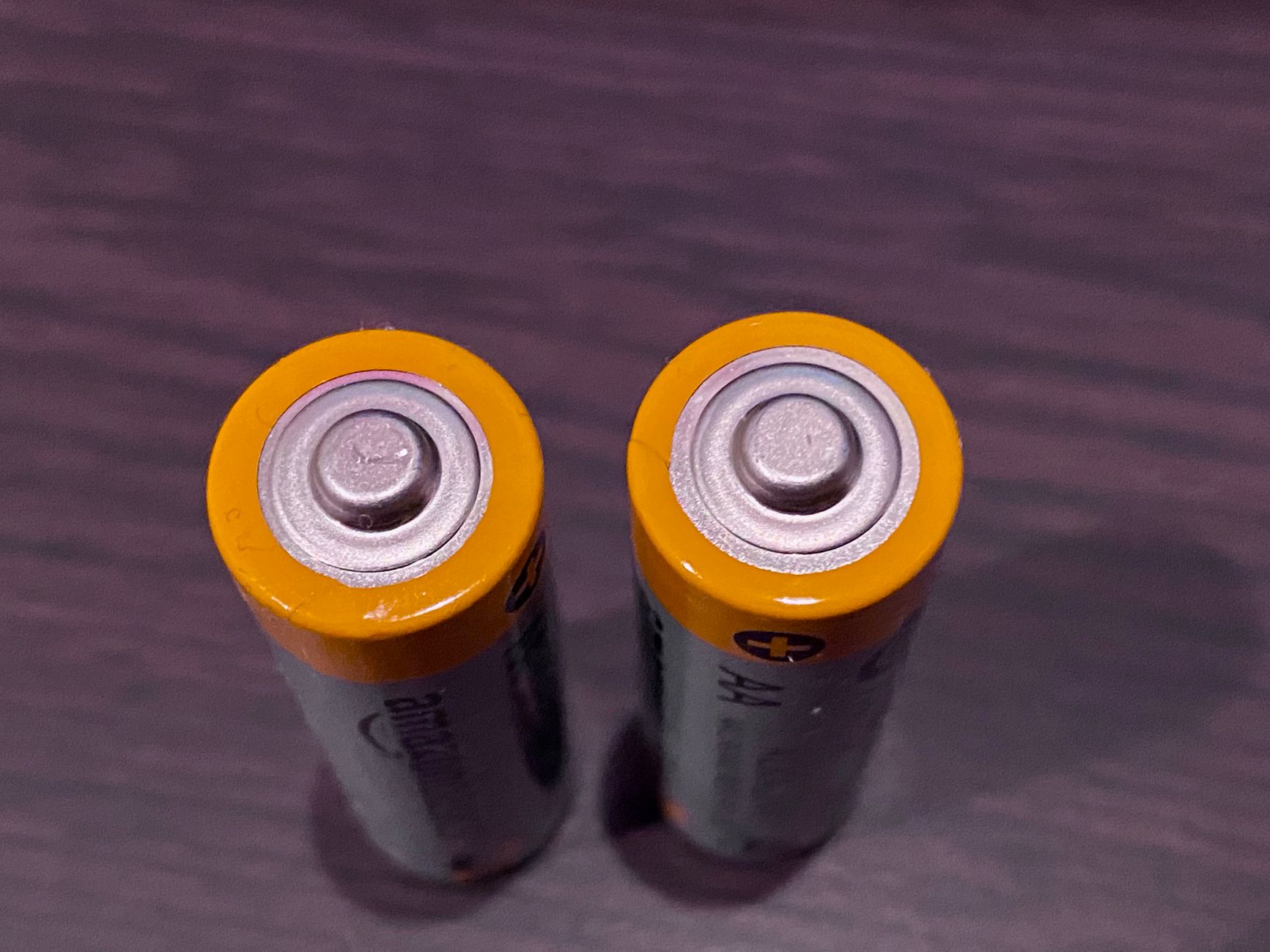 Two AA batteries standing on a table
