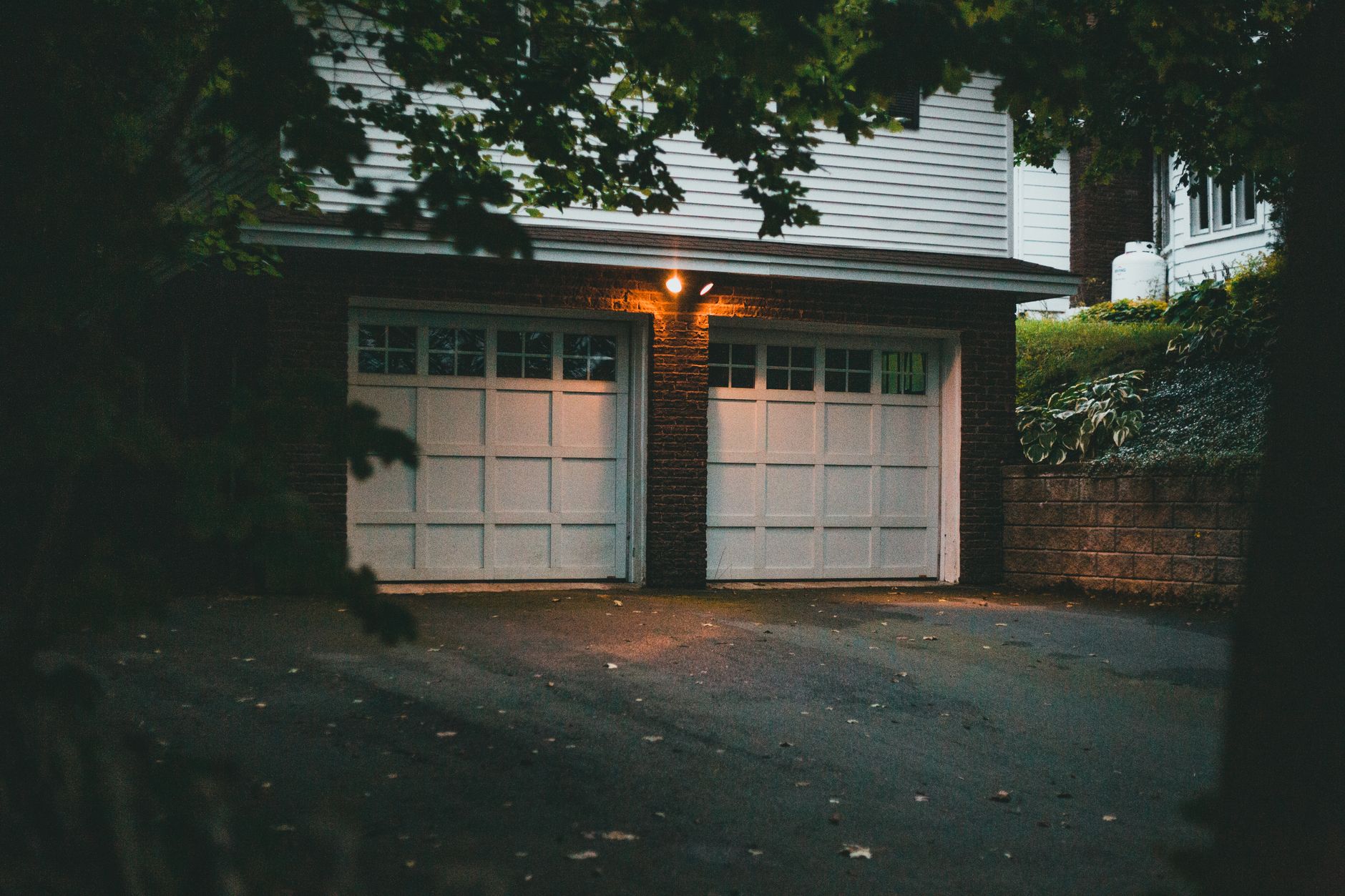 A two-car garage and driveway at dusk