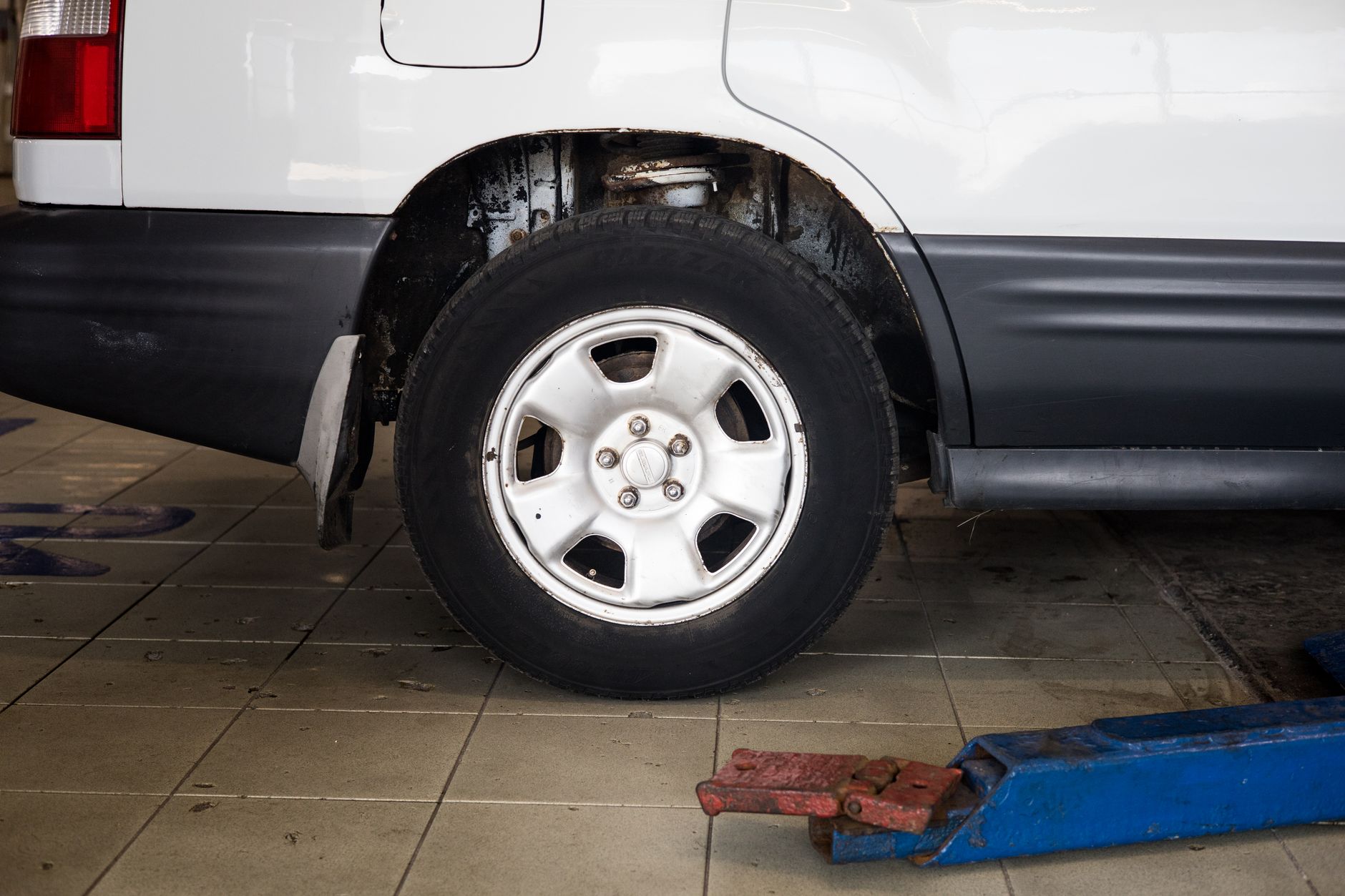 Best floor jack: a raised SUV with a jack under it