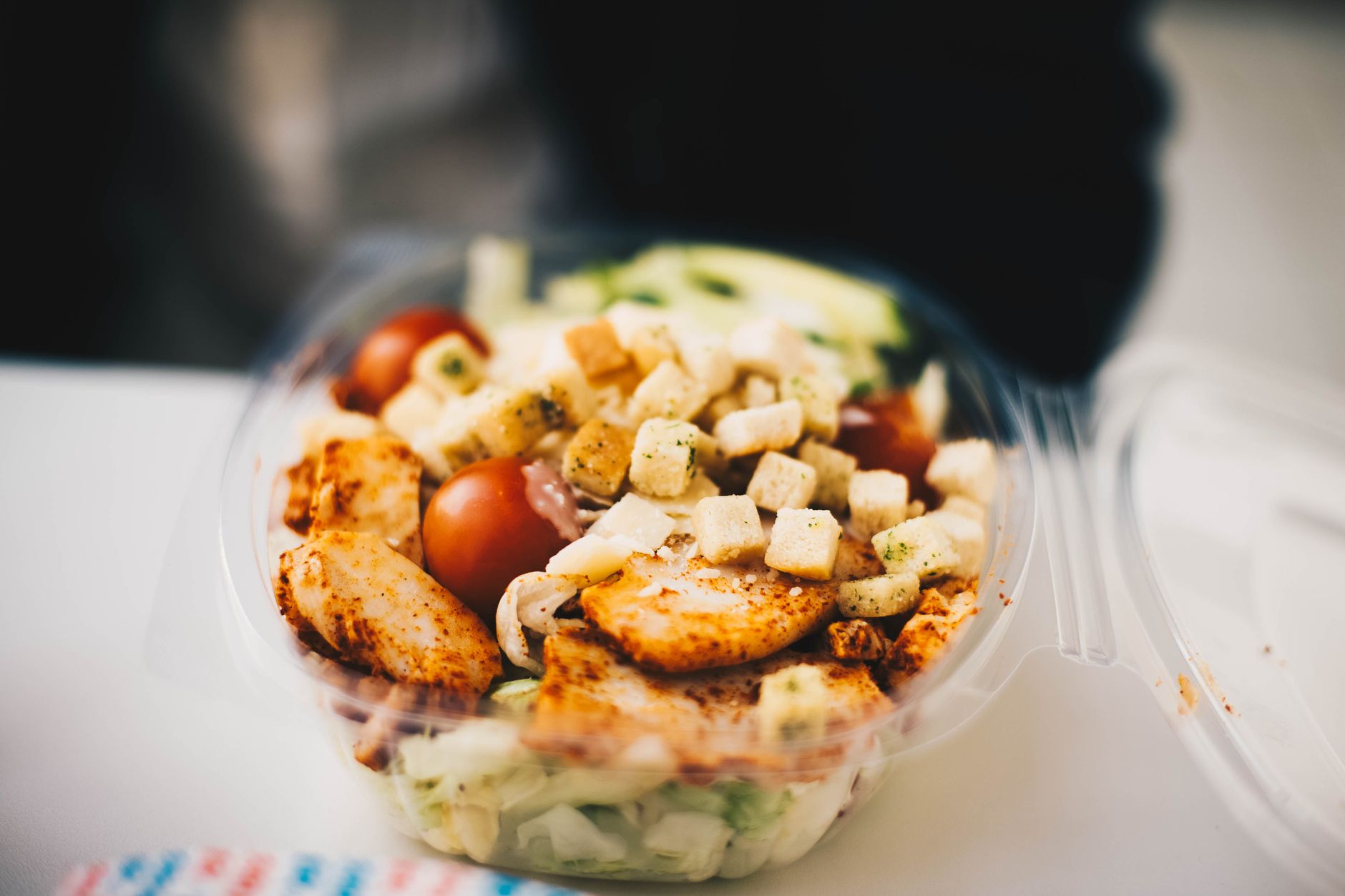 A salad in a clear takeout container