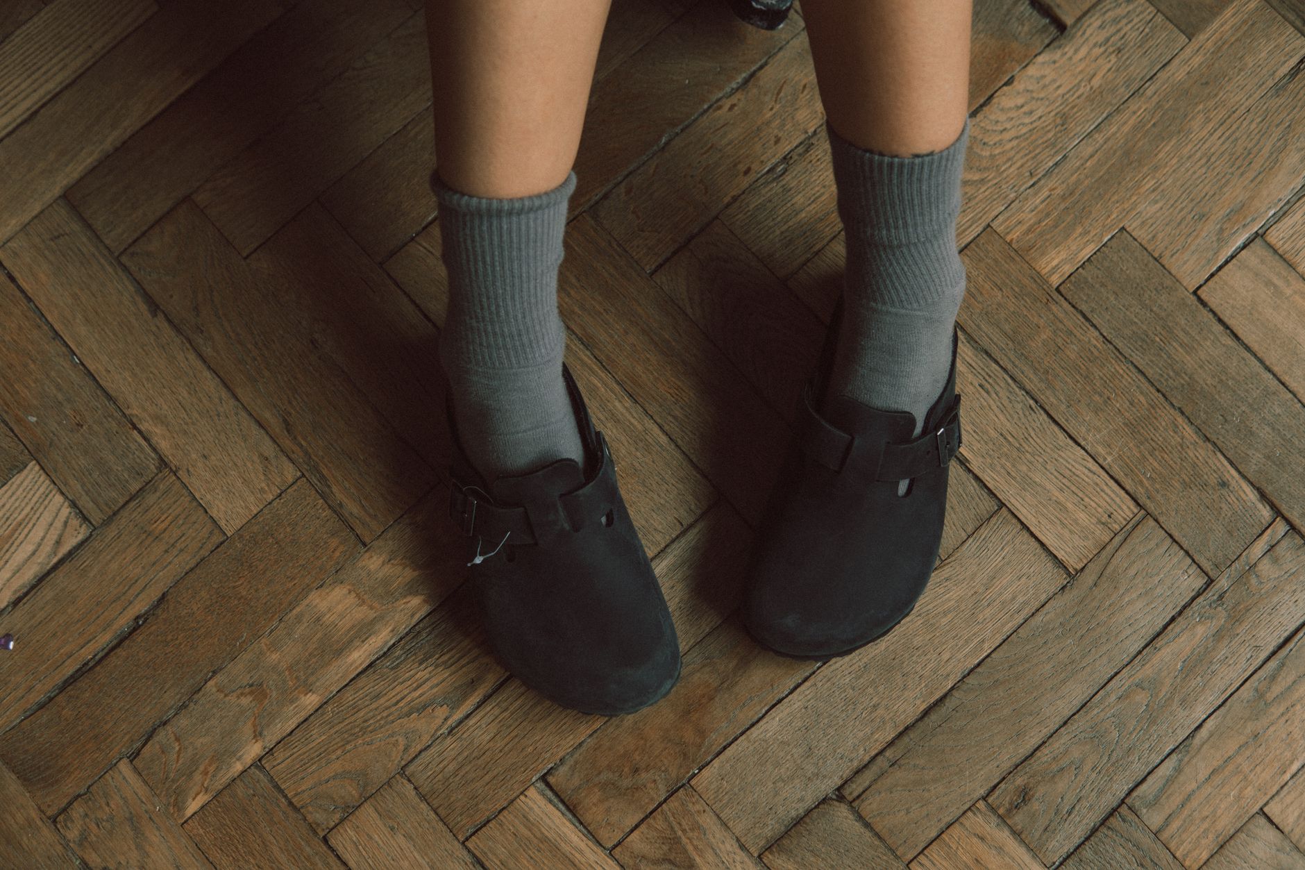 Feet in socks resting on a wooden floor