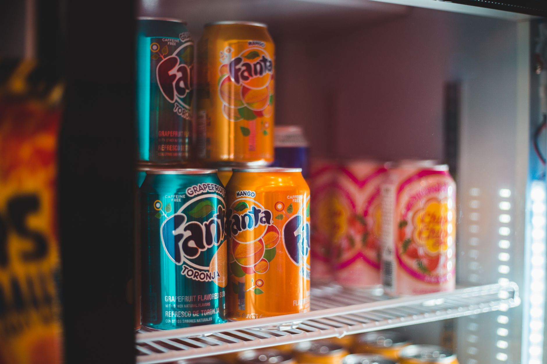 Soda cans in a lit drinks fridge