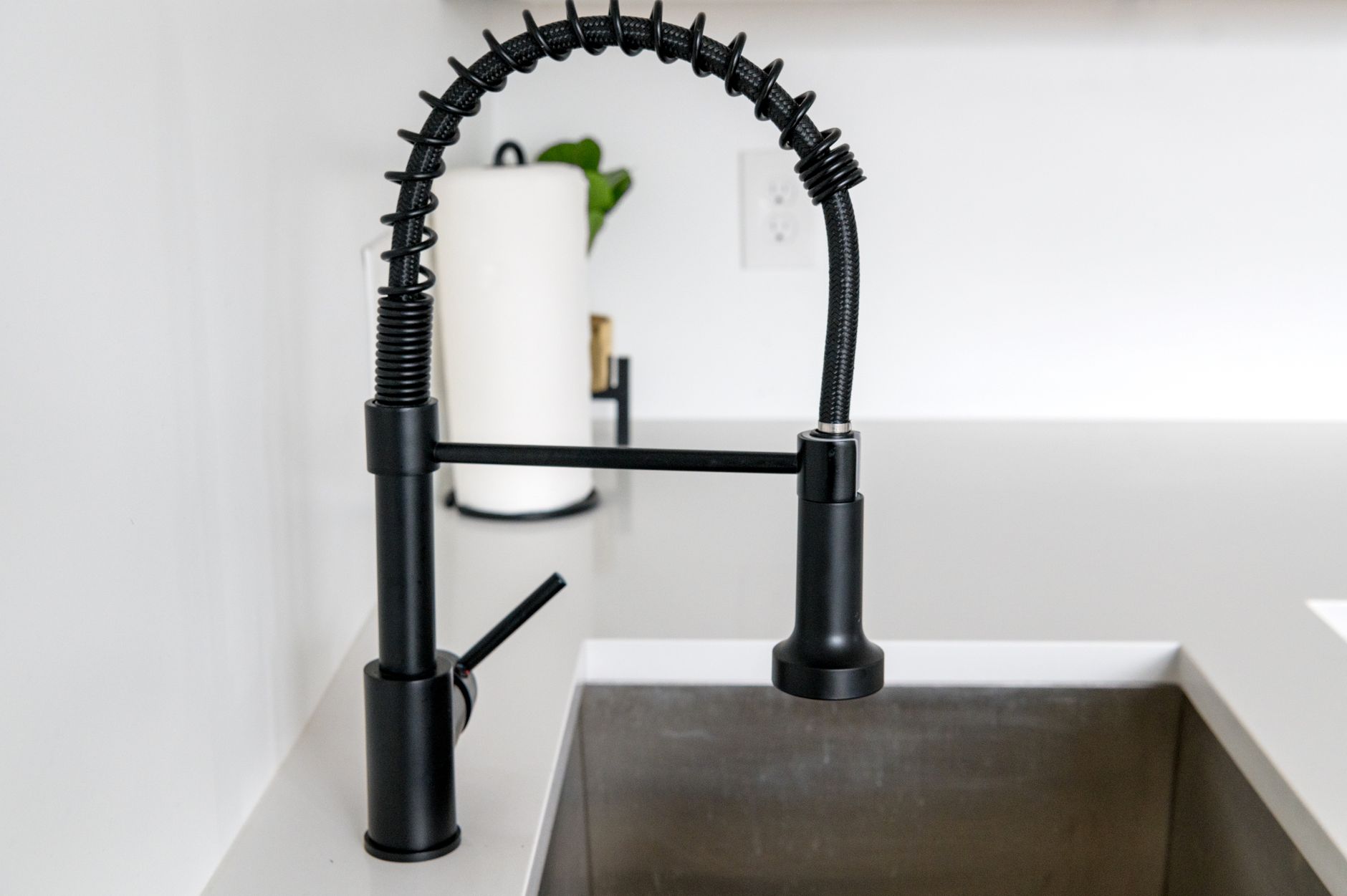 Best garbage disposal: a black pull-down faucet over a sink