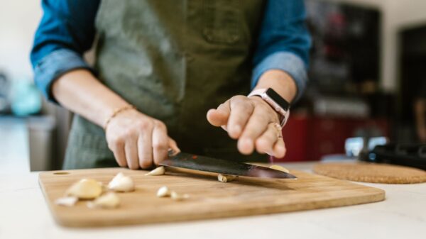 Best garlic press: chopping garlic on a wooden cutting board