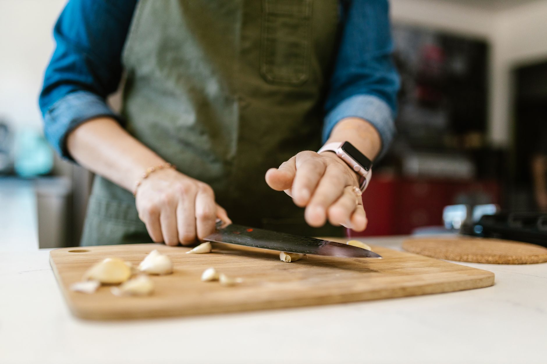 Best garlic press: chopping garlic on a wooden cutting board