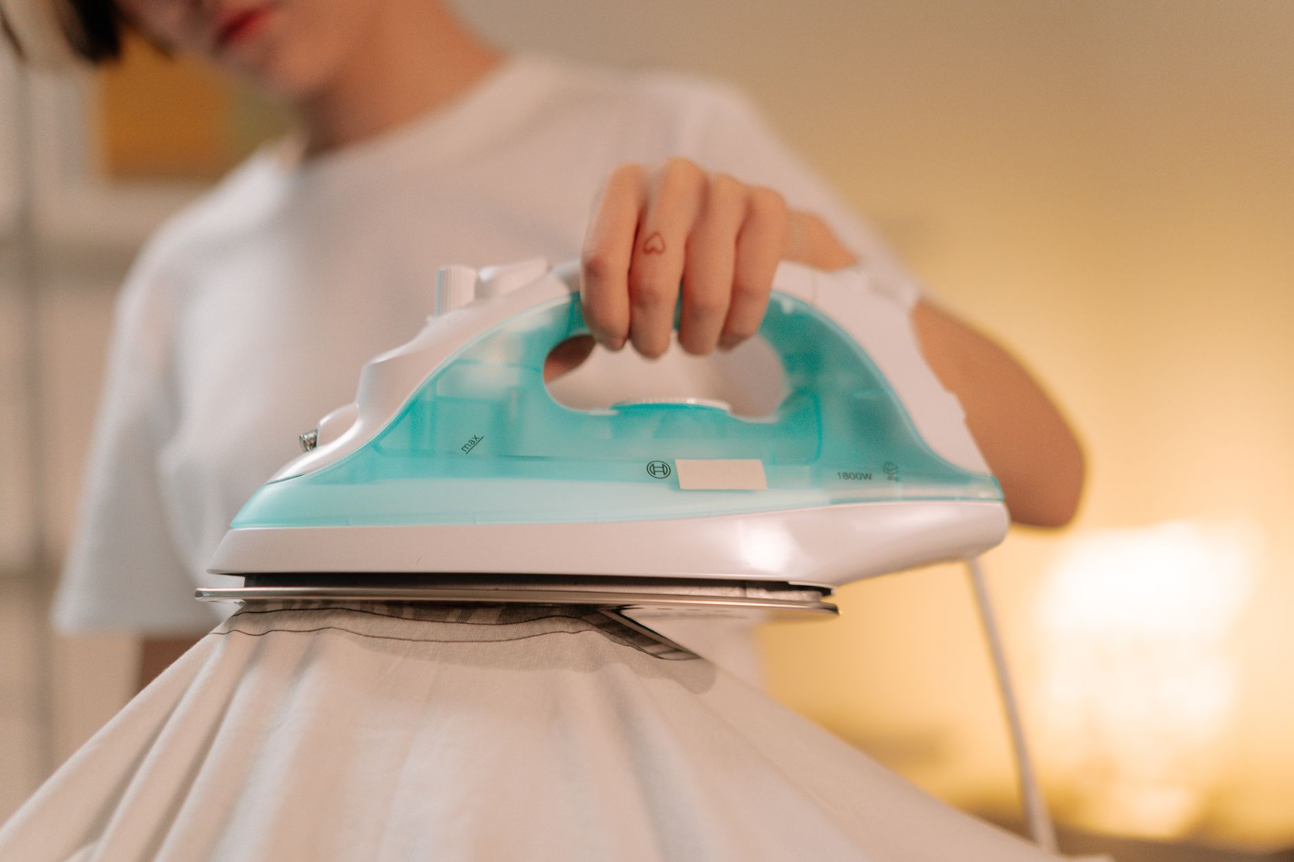 Ironing a shirt with a teal iron
