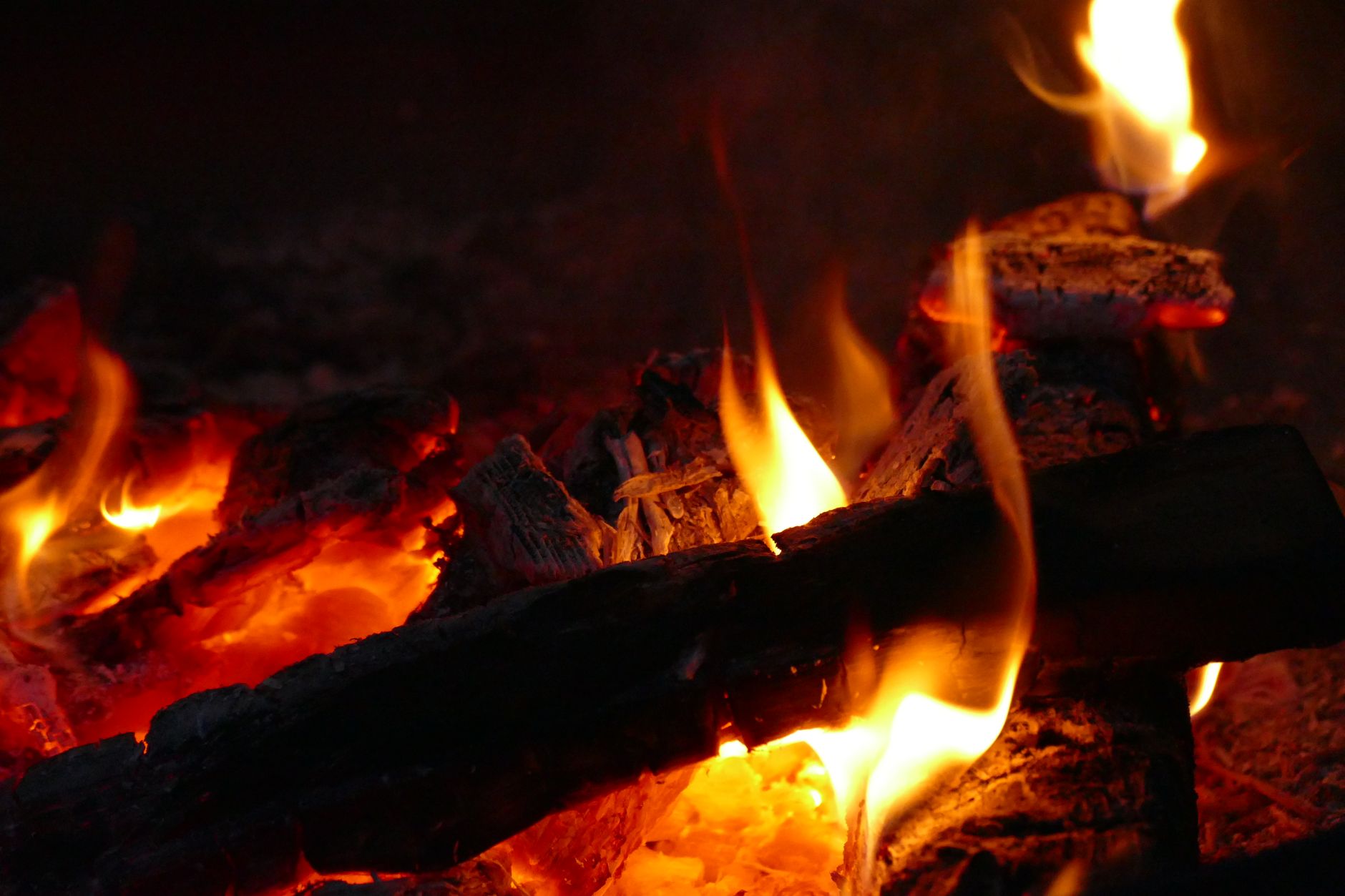 Logs burning over glowing embers