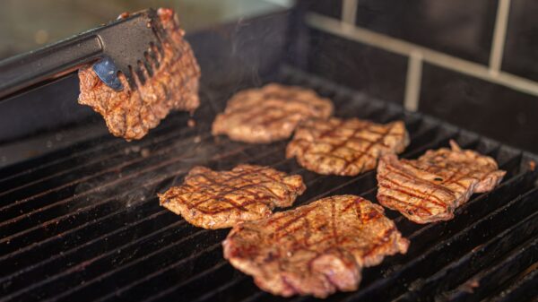 Best gas griddle: steaks cooking on a grill grate