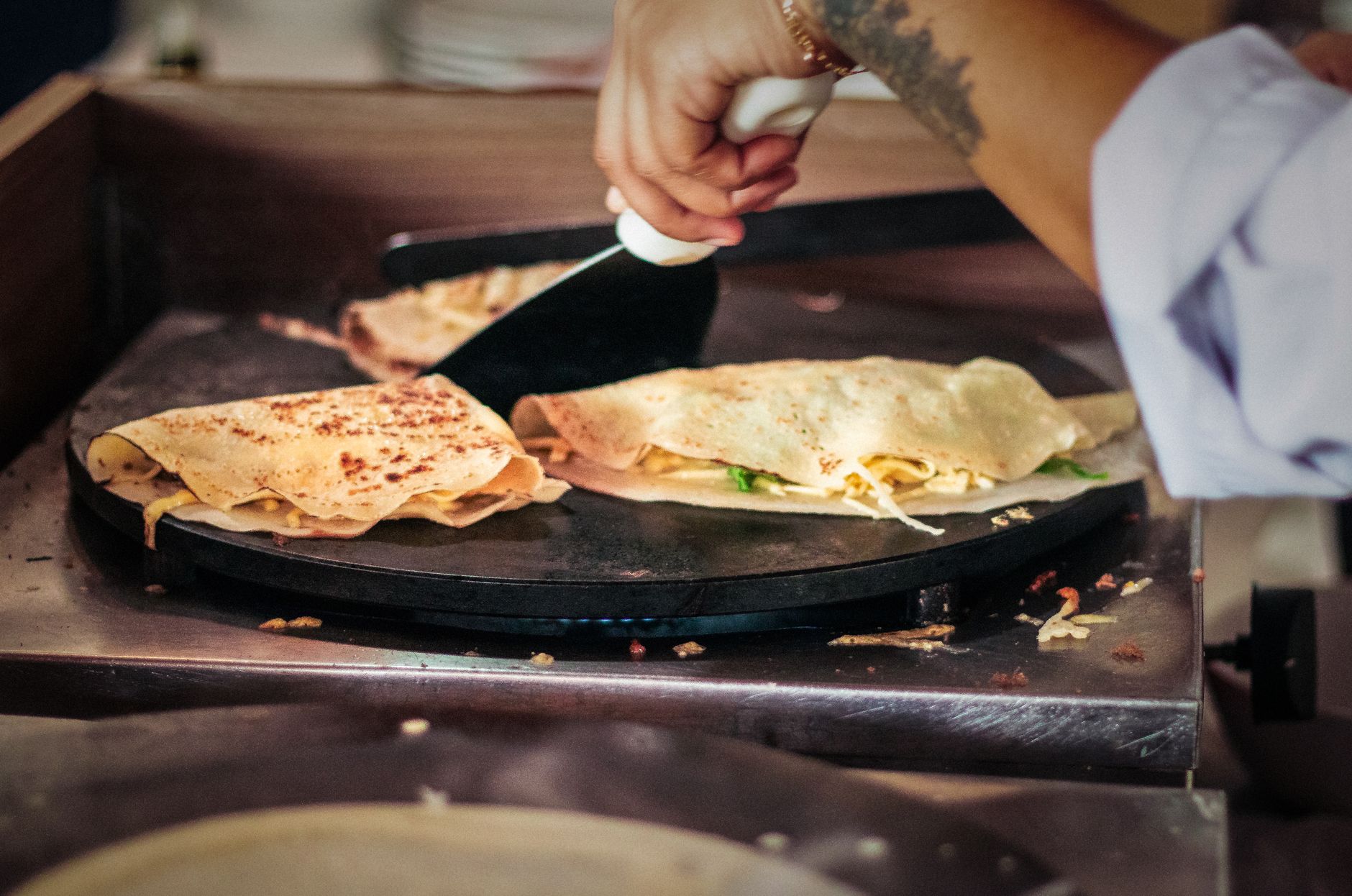 Crepes cooking on a flat griddle
