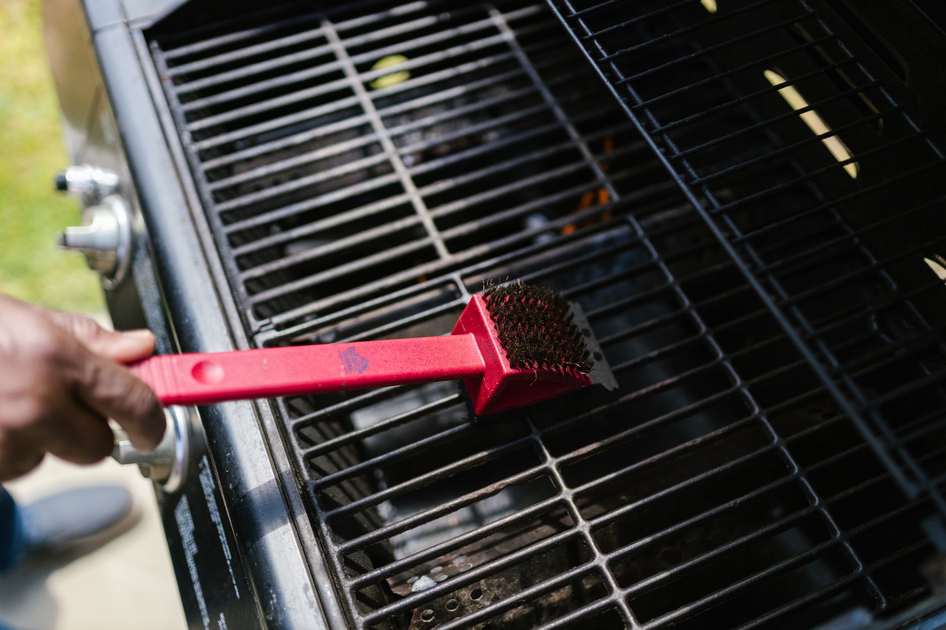 Cleaning a gas grill grate with a brush