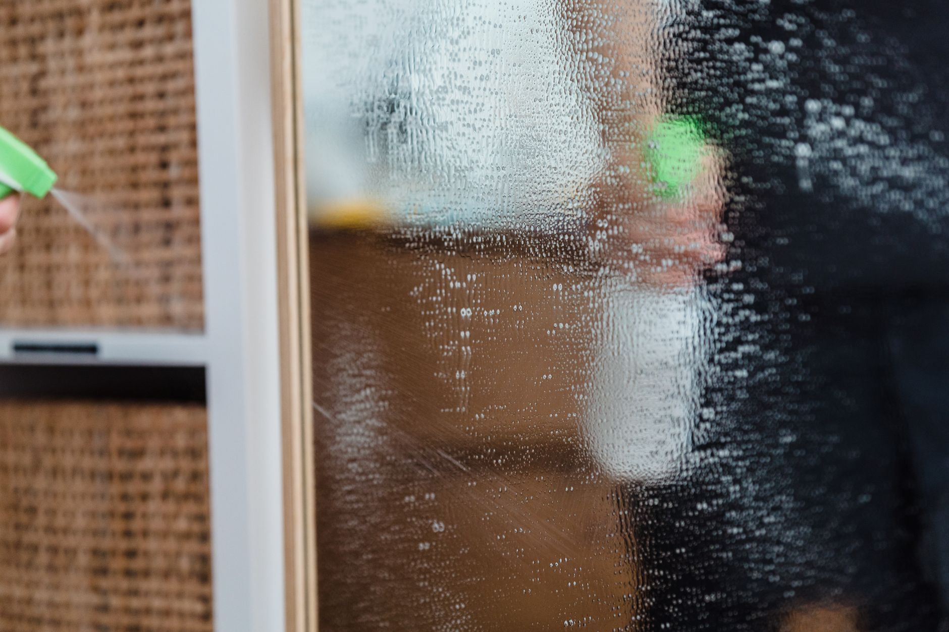 Spraying cleaner on glass