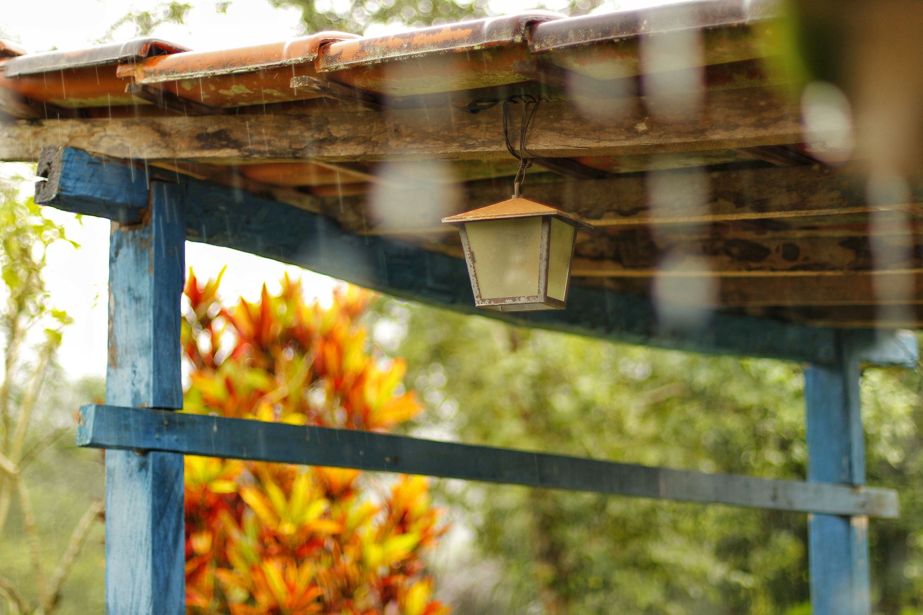 A wooden pergola with a hanging lantern