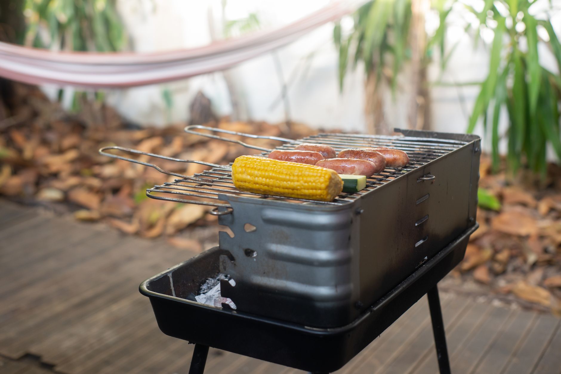 Best grill mat: a small charcoal grill on a wooden deck