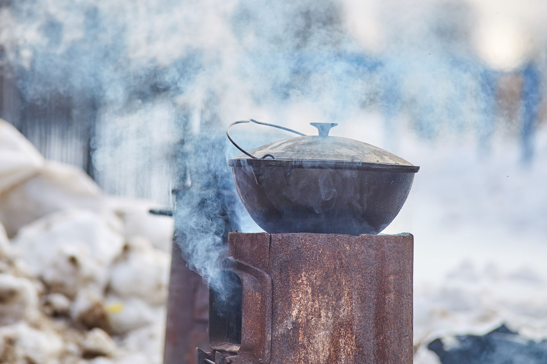 A pot on a camp stove in the snow