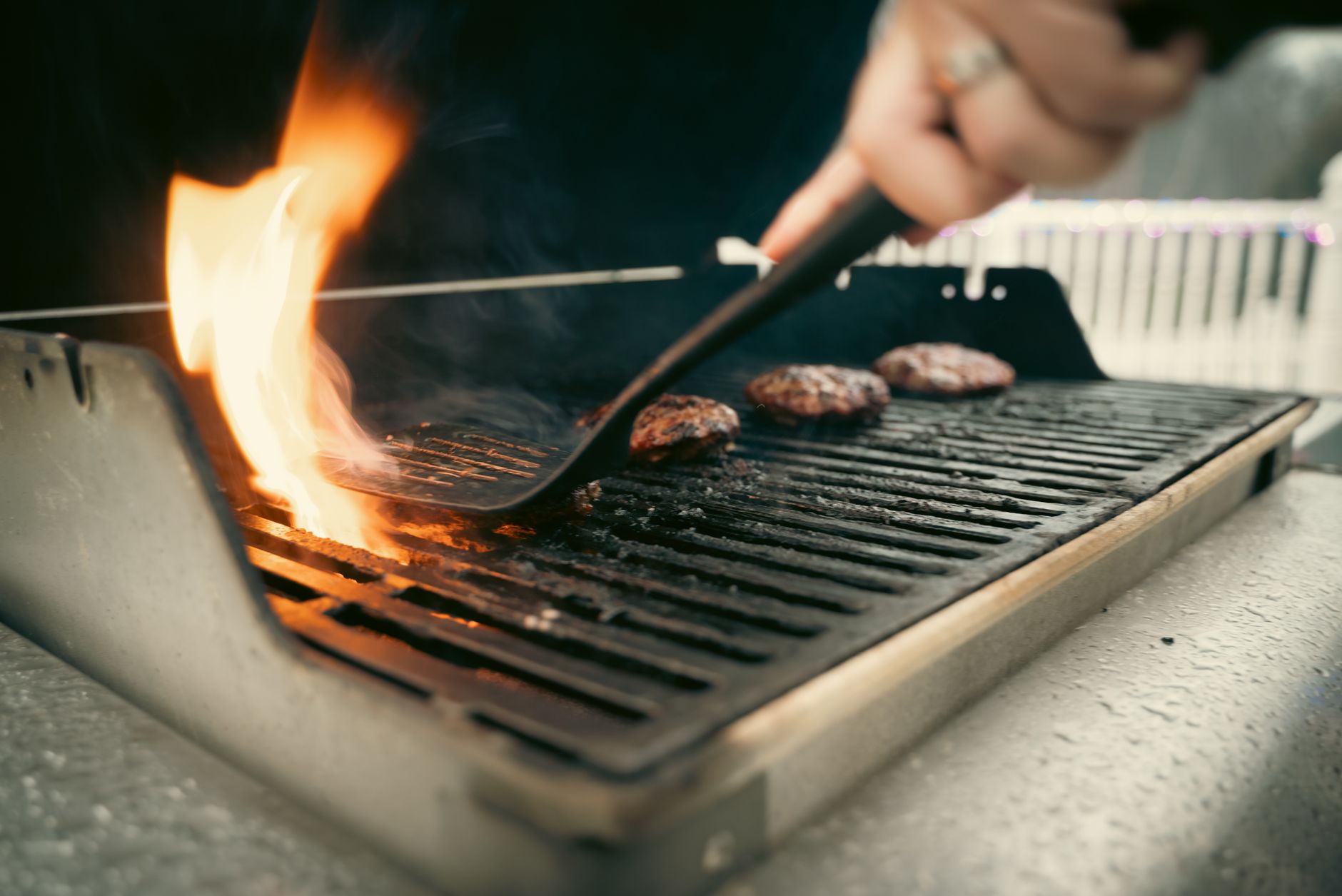 Flipping burgers on a gas grill
