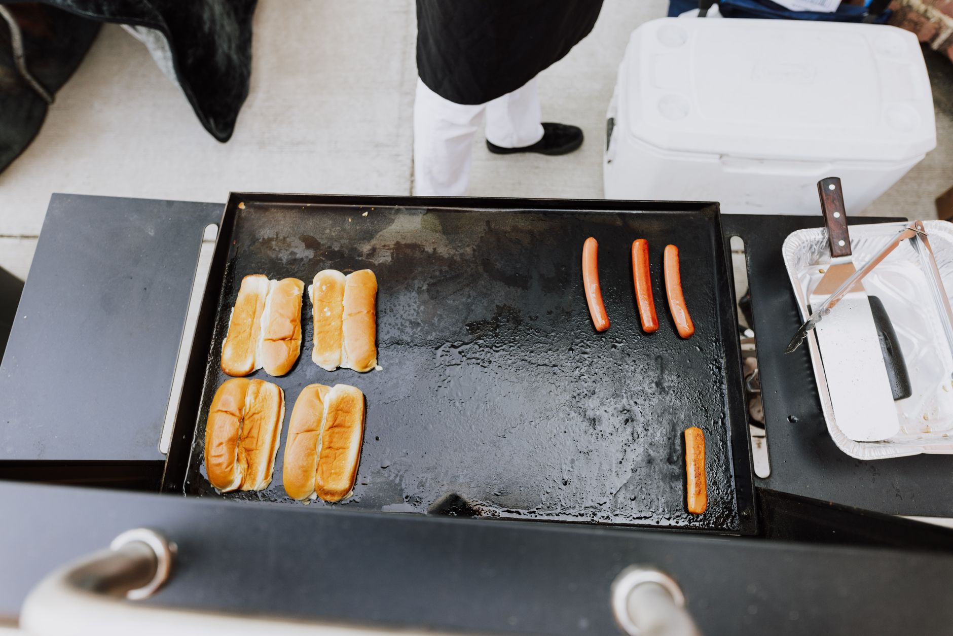 Hot dogs and buns on a flat-top griddle