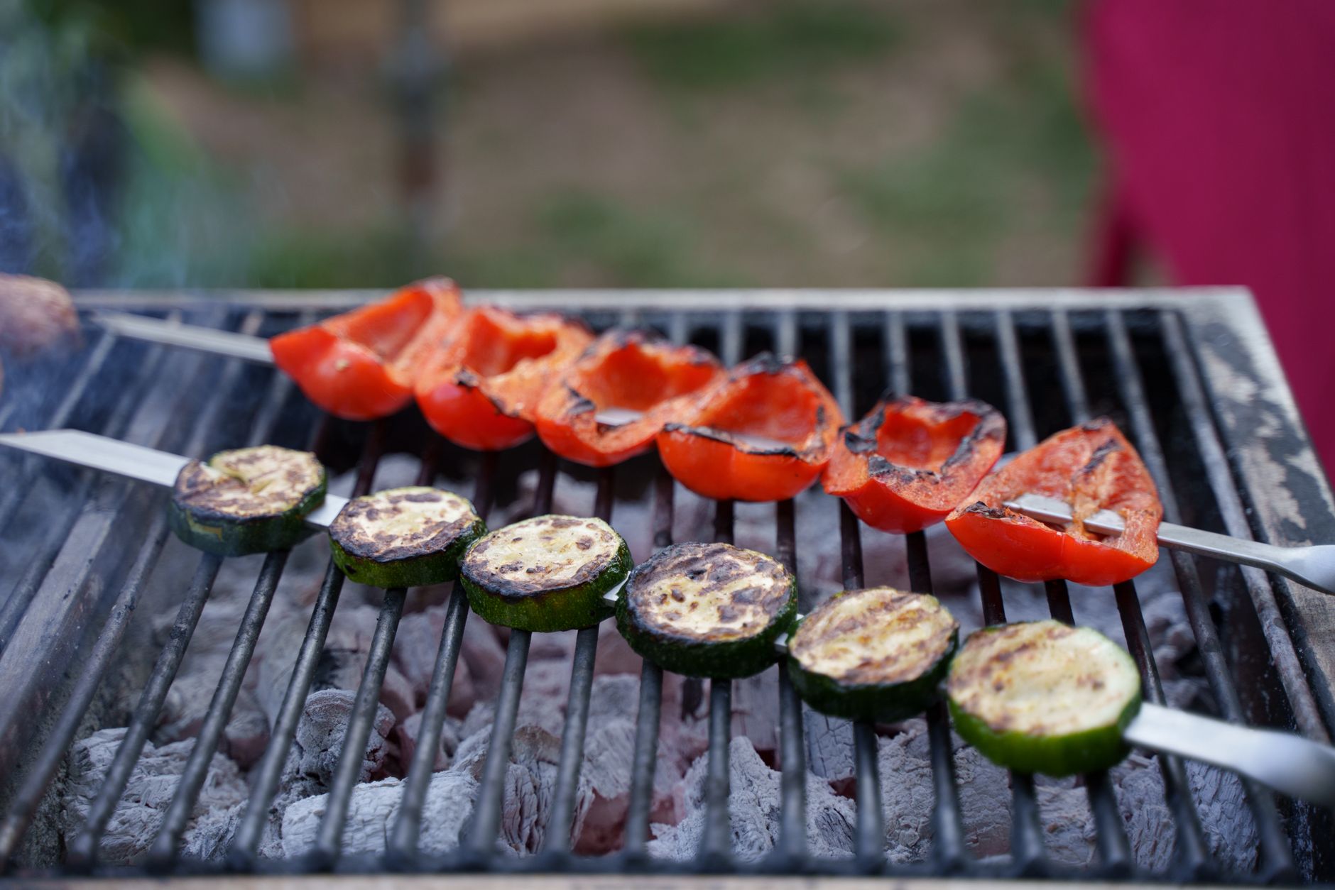 Vegetables and skewers cooking on a grill