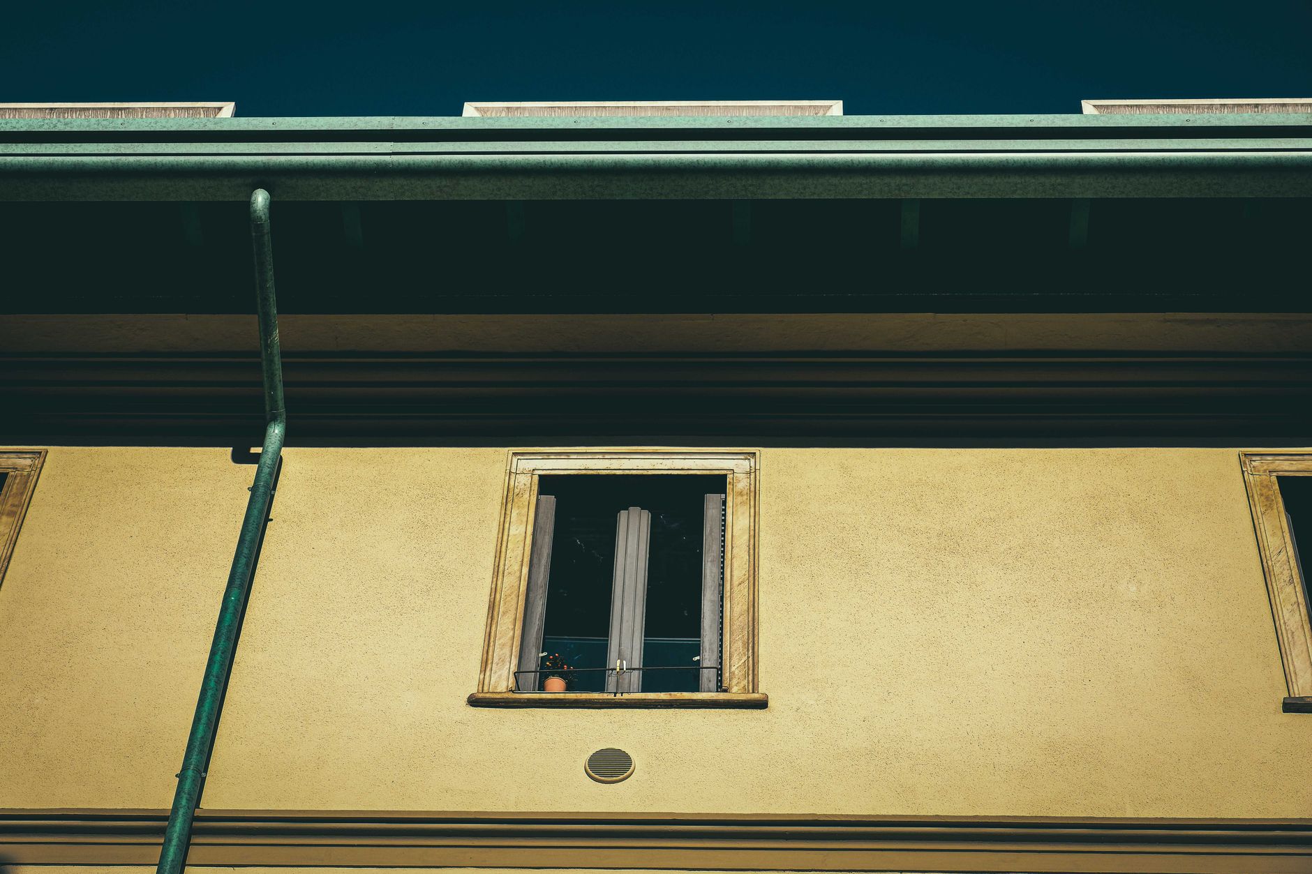 Best gutter cleaning tool: a gutter and downspout along a roofline