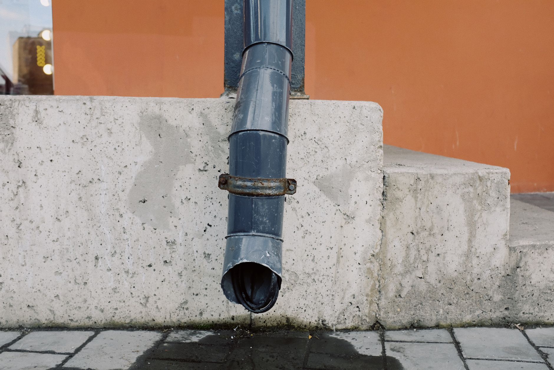 A downspout above concrete steps
