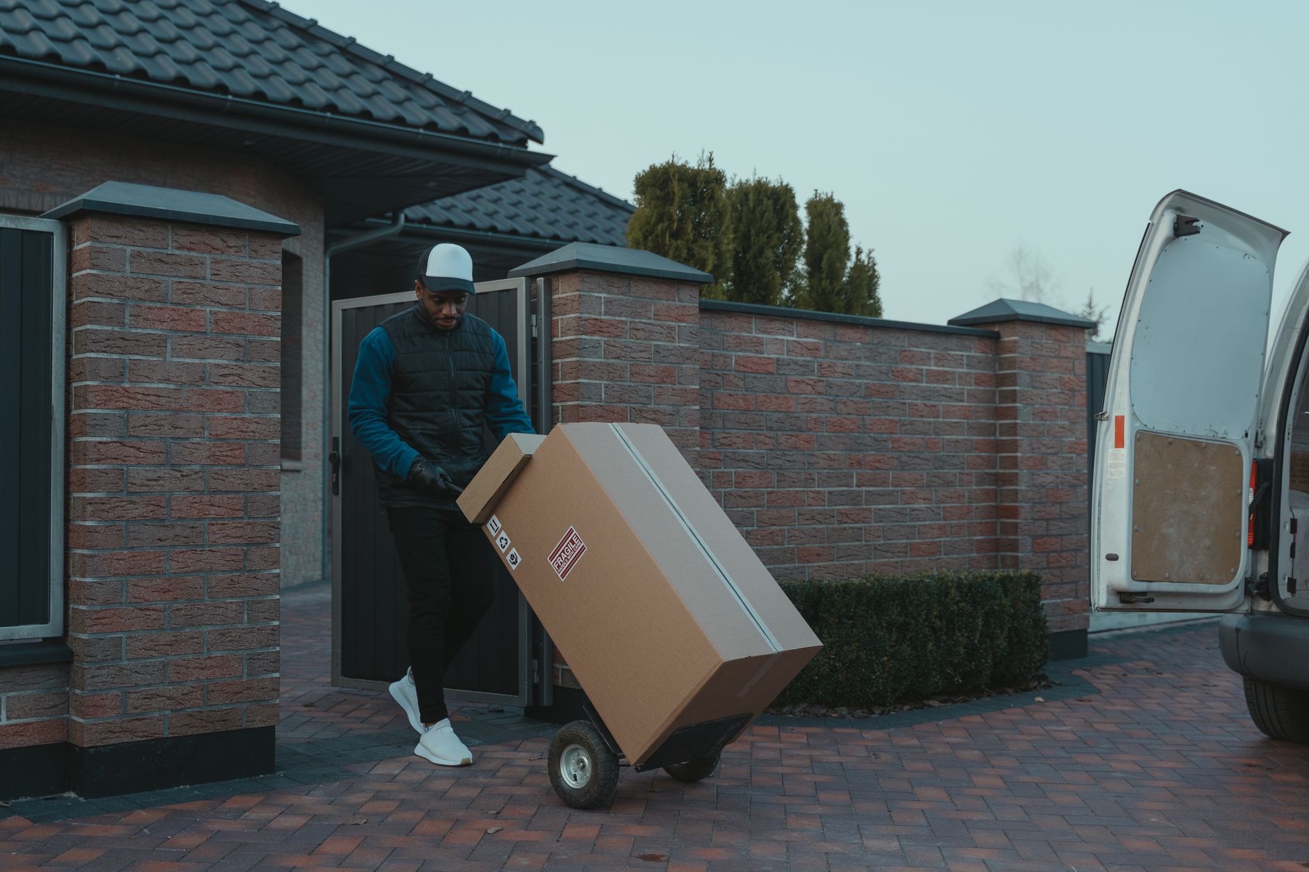 Best hand truck: a mover wheeling a box on a hand truck